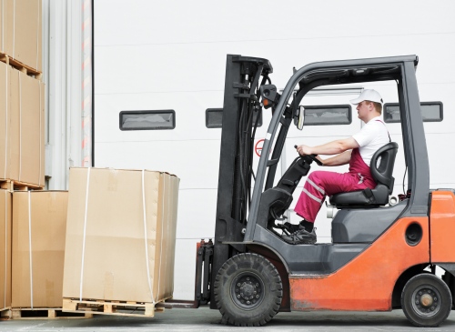 Forklift Driver working outside and loading a stack of boxes