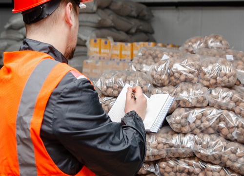 Grocery Warehouse worker checking inventory of produce